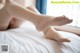 A woman laying on top of a bed with her feet up.