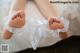 A close up of a baby's feet in a white dress.