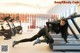 A woman doing a plank on a treadmill in a gym.