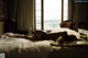 A woman laying on a bed in front of a window.