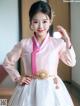 A young girl wearing a pink and white hanbok.